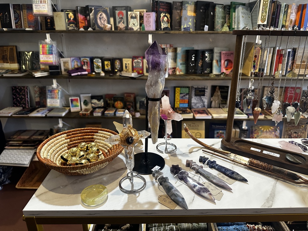 Amethyst and quartz pieces on a marble table with book shelves behind
